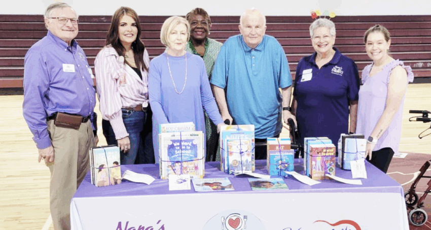 School board members also showed their support for literacy in Madison at the school assemblies. Pictured, from left to right, are: Dr. Dennis Dulniak, Nana’s Book Foundation President; Devin Thompson, school board member; Bertha Allen, Nana’s Book Foundation sponsor; VeEtta Hagan, school board member; Gordie Allen, Nana’s Book Foundation sponsor; Toni Gitles, Dr. Dulniak’s fiancé; and Katie Roberts, MCCS Media Specialist. [Nana’s Book Foundation/Courtesy]